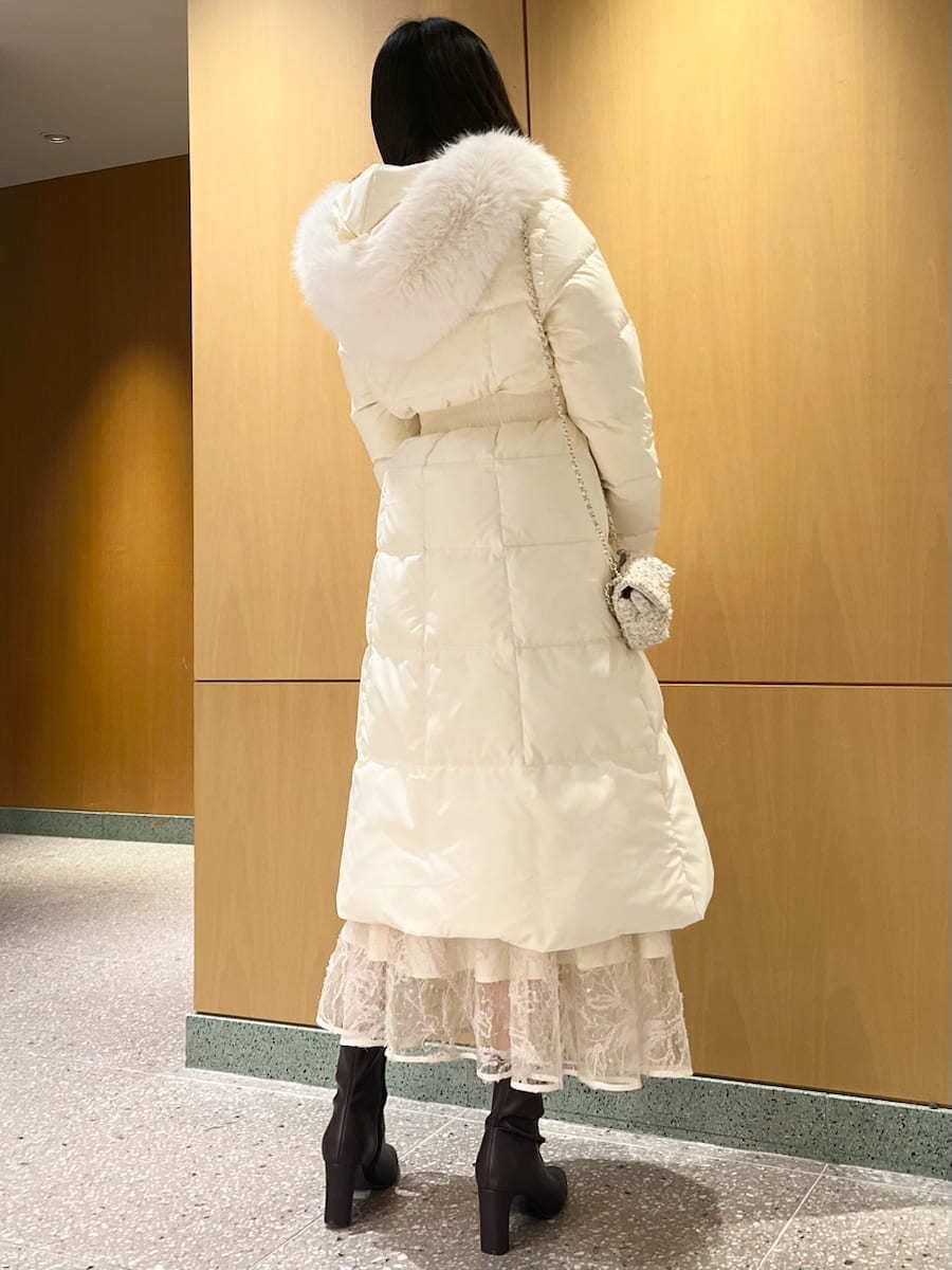 レッド系のブーツ、ホワイト系のショルダーバッグ、ピンク系のニット/セーターを着用したレディースの冬コーディネートの2枚目の写真