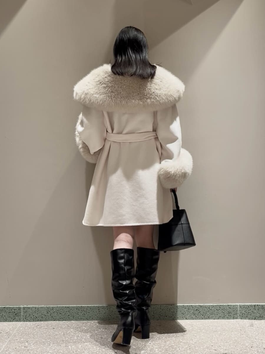 ホワイト系のチェスターコート、ブラック系のその他パンツ、ブラック系のハンドバッグを着用したレディースの冬コーディネートの3枚目の写真