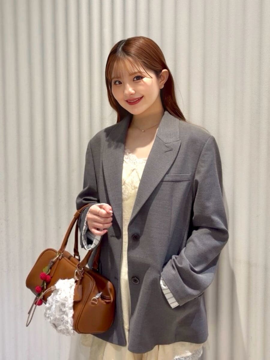 グレー系のテーラードジャケット、ブルー系のデニムパンツ、イエロー系のキャミソールを着用したレディースの春コーディネートの6枚目の写真
