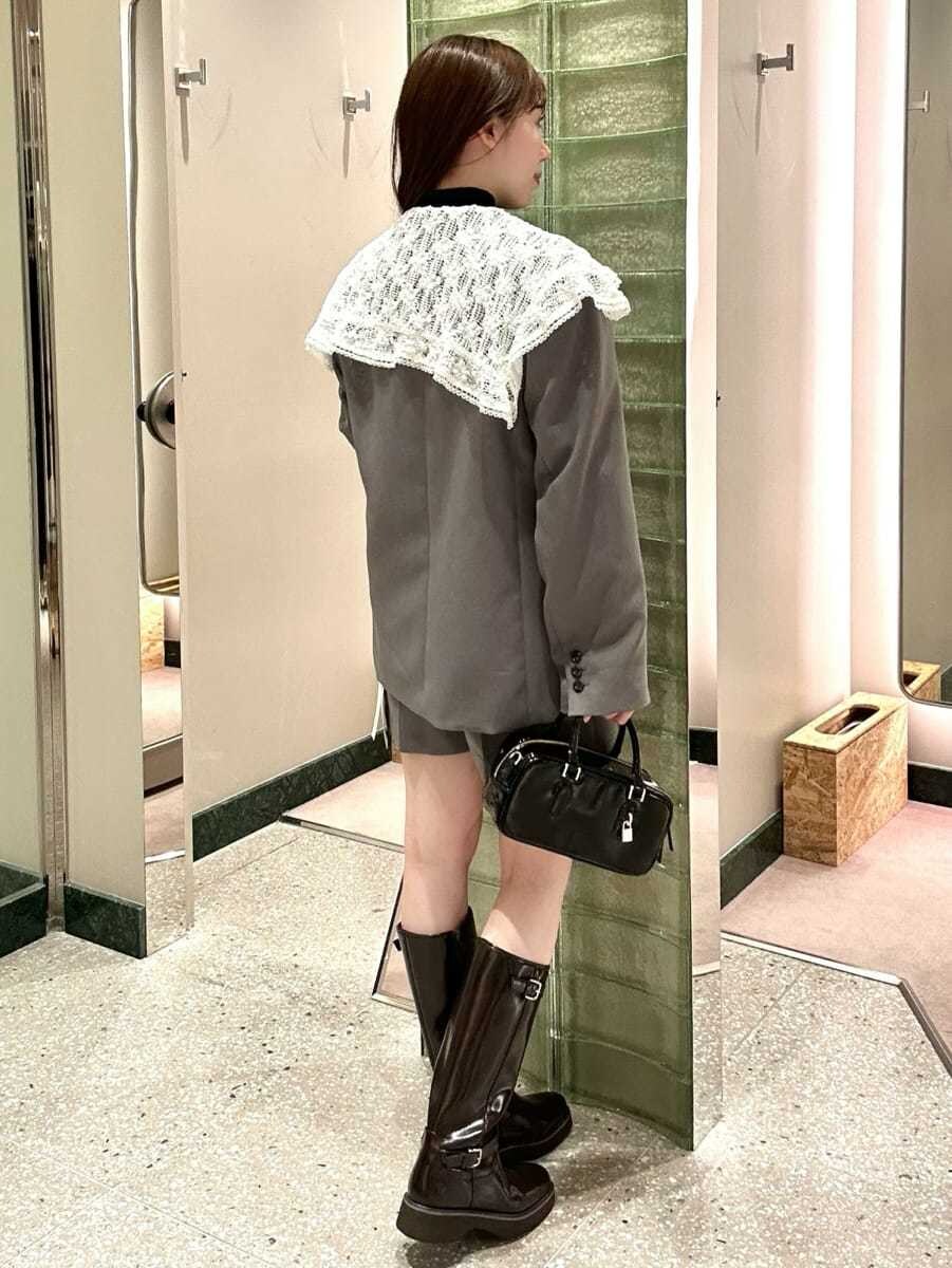 グレー系のテーラードジャケット、グレー系のその他パンツ、ブラウン系のブーツを着用したレディースの秋コーディネートの4枚目の写真