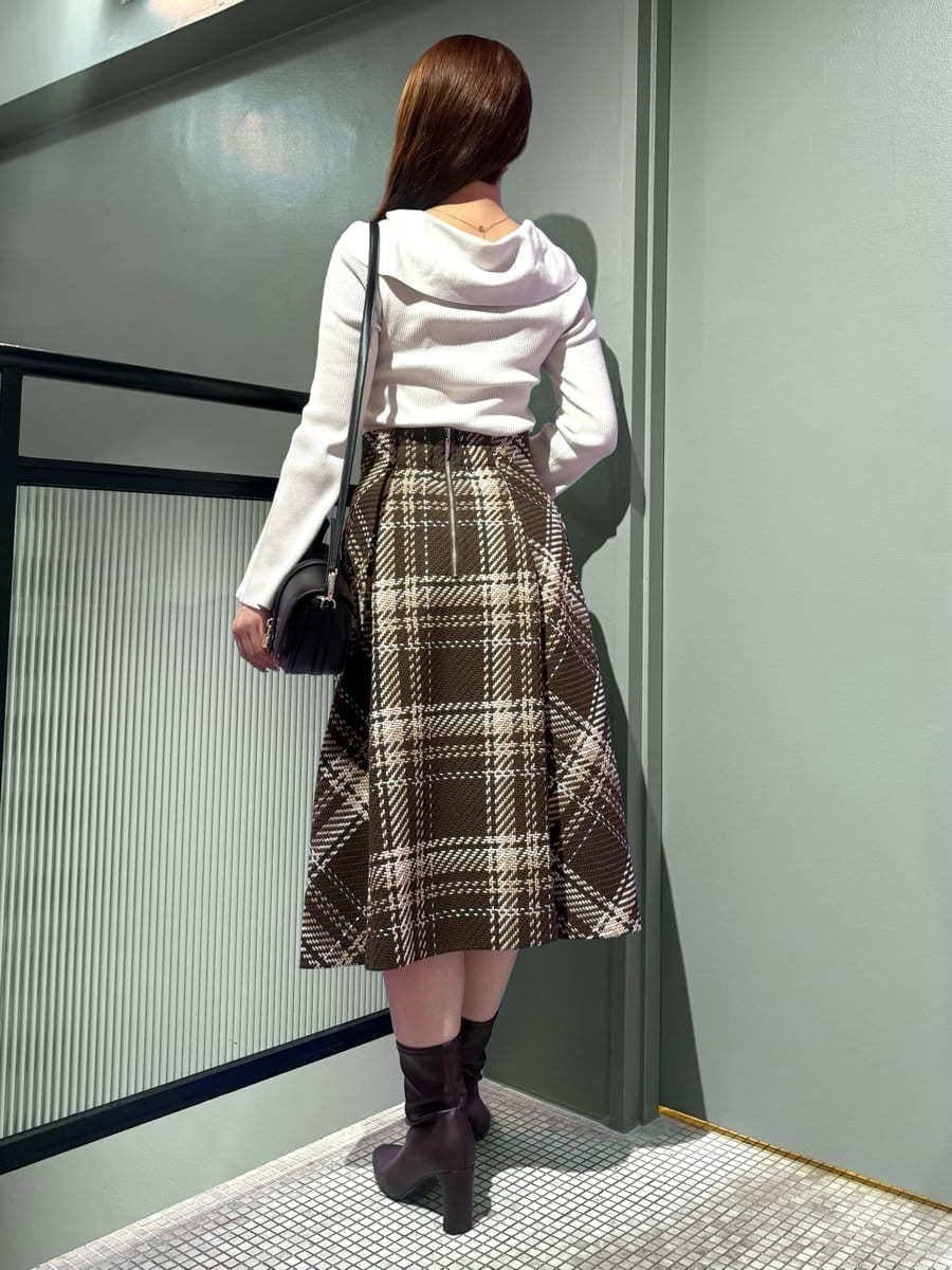 ホワイト系のニット/セーター、ブラウン系のスカート、レッド系のブーツを着用したレディースの秋コーディネートの3枚目の写真