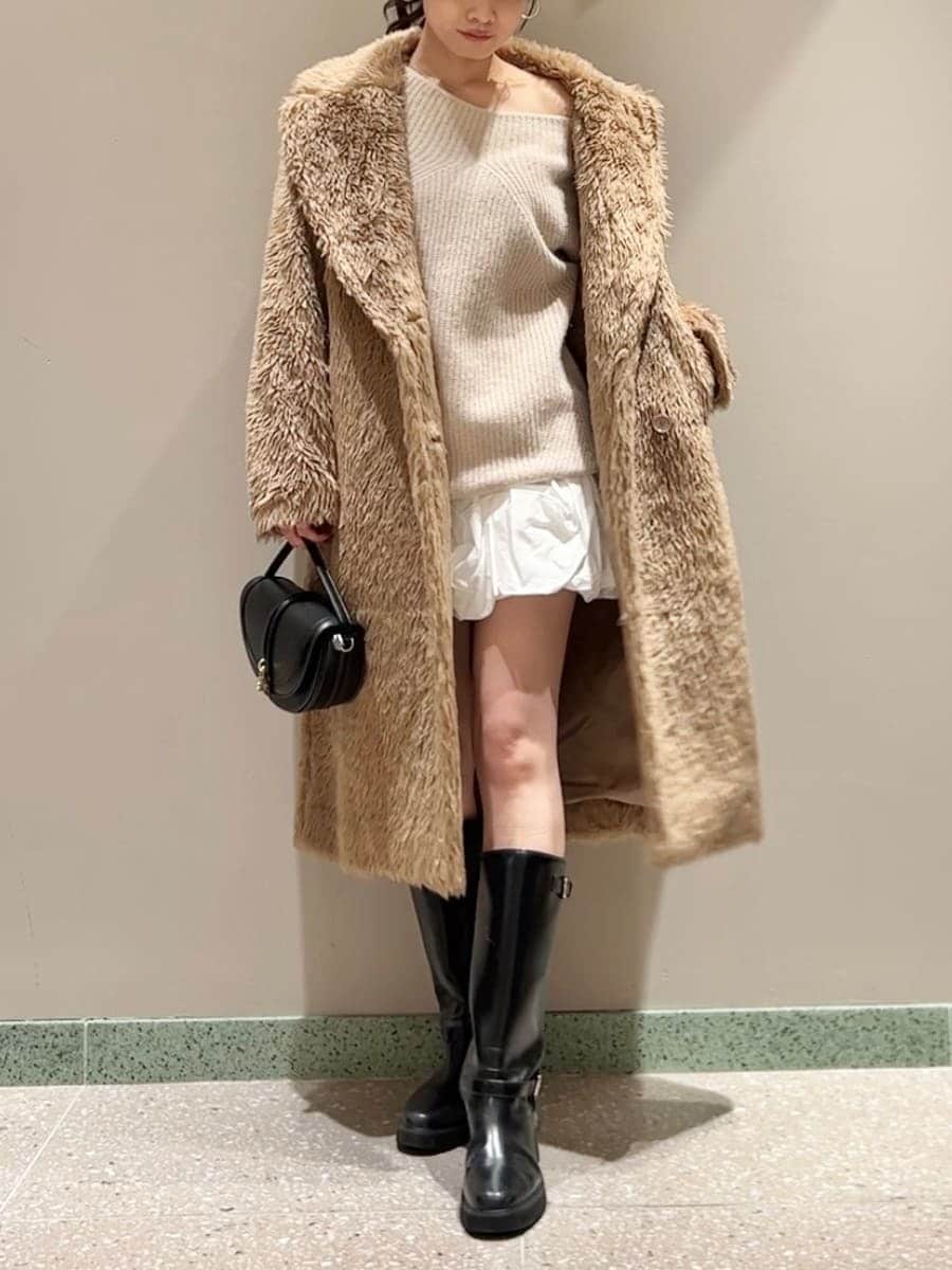 ブラック系のブーツ、ブラック系のハンドバッグ、ホワイト系のその他パンツを着用したレディースの冬コーディネートの2枚目の写真