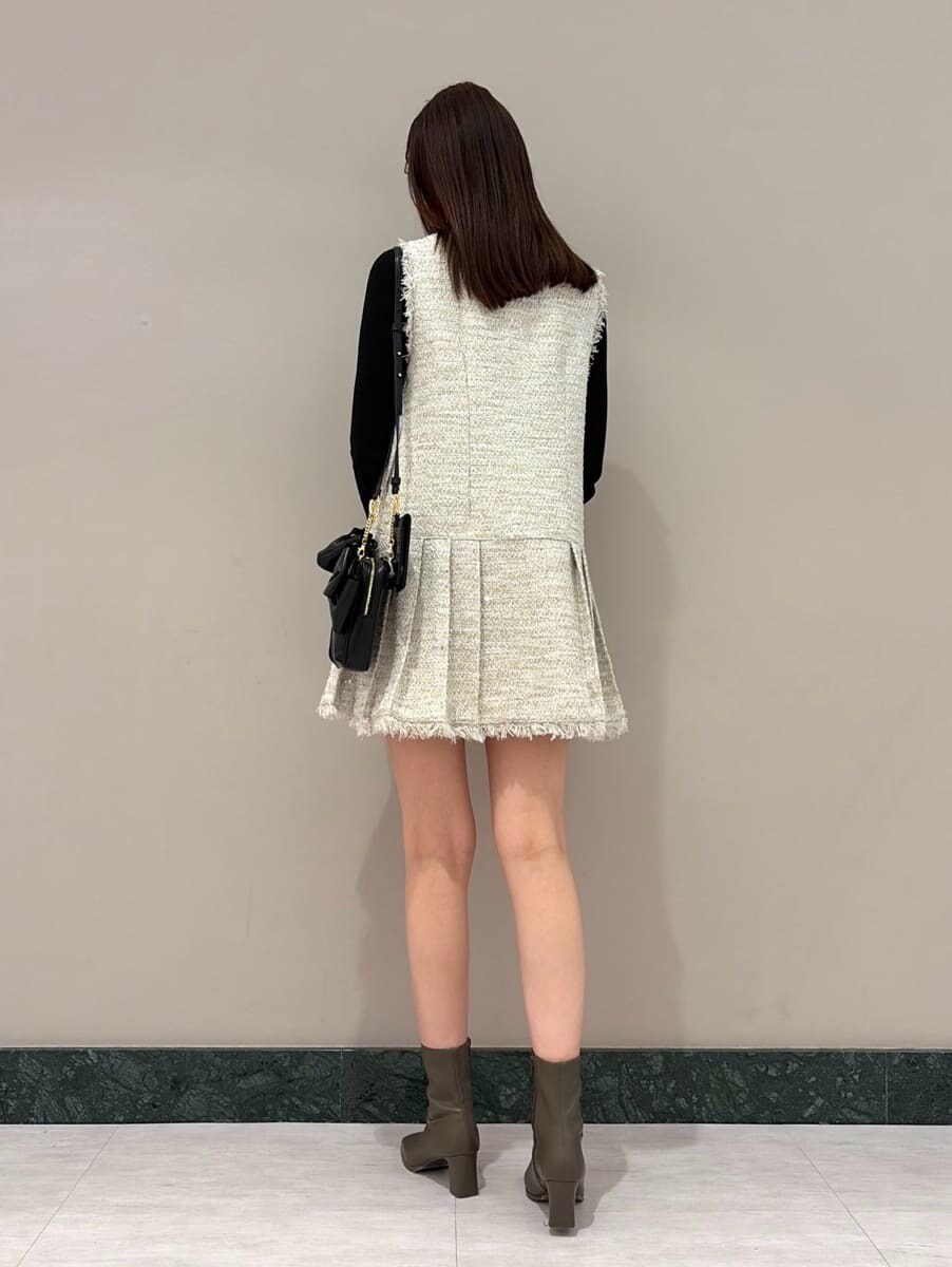 ホワイト系のワンピース、ブラック系のニット/セーター、ブラック系のショルダーバッグを着用したレディースの冬コーディネートの4枚目の写真