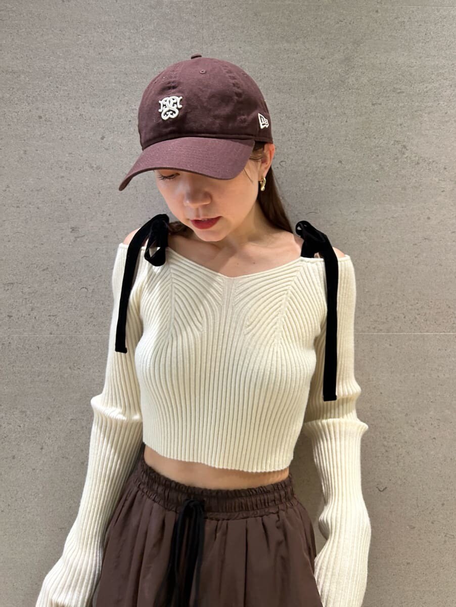 ホワイト系のニット/セーター、ブラウン系のその他パンツ、ブラック系のボストンバッグを着用したレディースの夏コーディネートの3枚目の写真