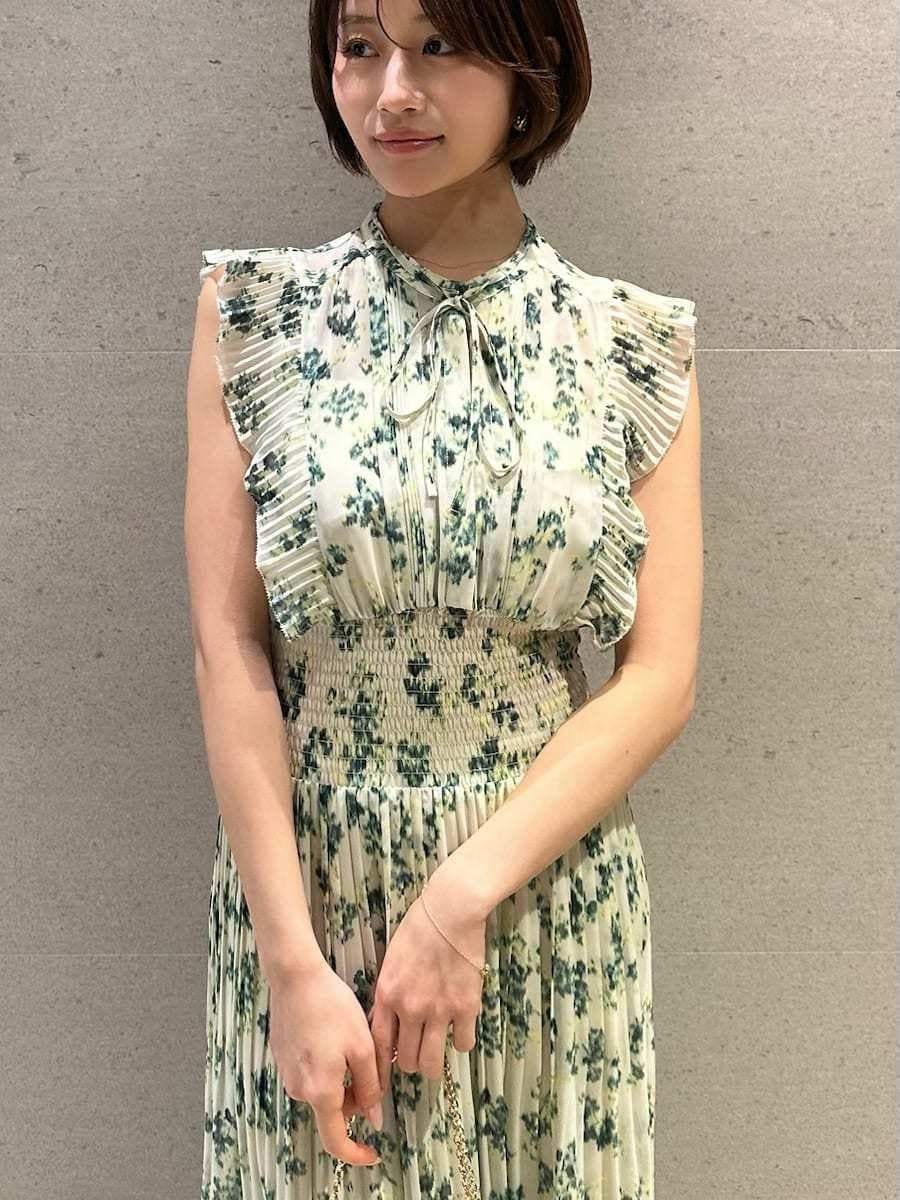 グリーン系のワンピース、ホワイト系のカーディガン/ボレロ、ブラウン系のパンプスを着用したレディースの冬コーディネートの9枚目の写真