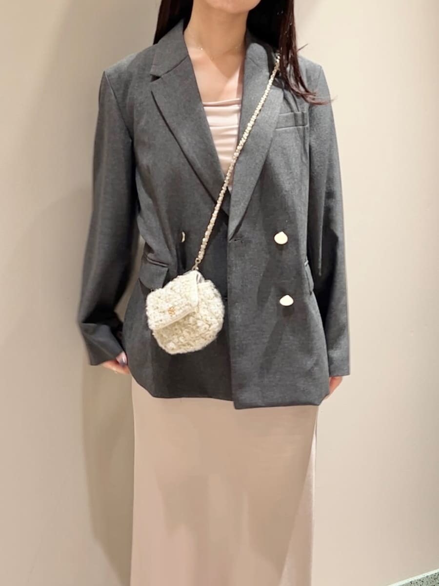 グレー系のテーラードジャケット、ホワイト系のショルダーバッグを着用したレディースの秋コーディネートの4枚目の写真