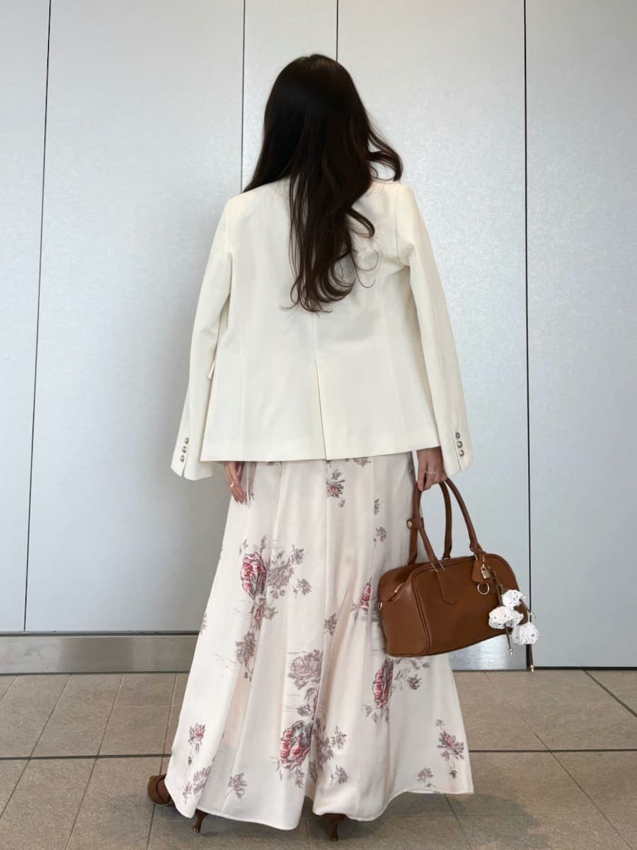 ホワイト系のテーラードジャケット、ホワイト系のワンピース、ブラウン系のパンプスを着用したレディースの春コーディネートの4枚目の写真