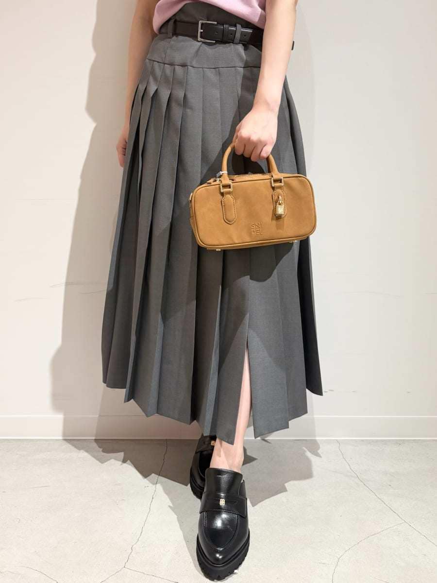 イエロー系のボストンバッグ、ピンク系のニット/セーター、グレー系のスカートを着用したレディースの夏コーディネートの6枚目の写真