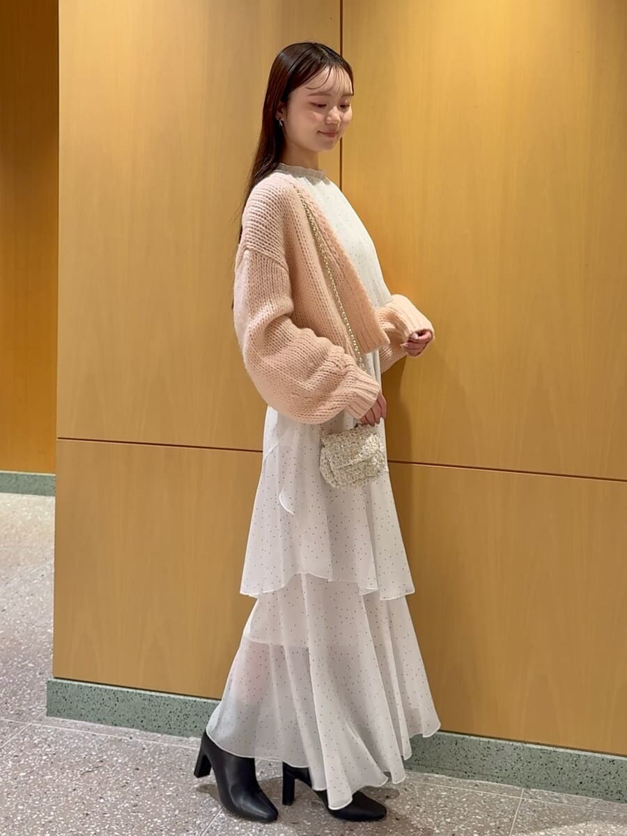 ブラック系のブーツ、ホワイト系のショルダーバッグ、その他のワンピースを着用したレディースの冬コーディネートの2枚目の写真