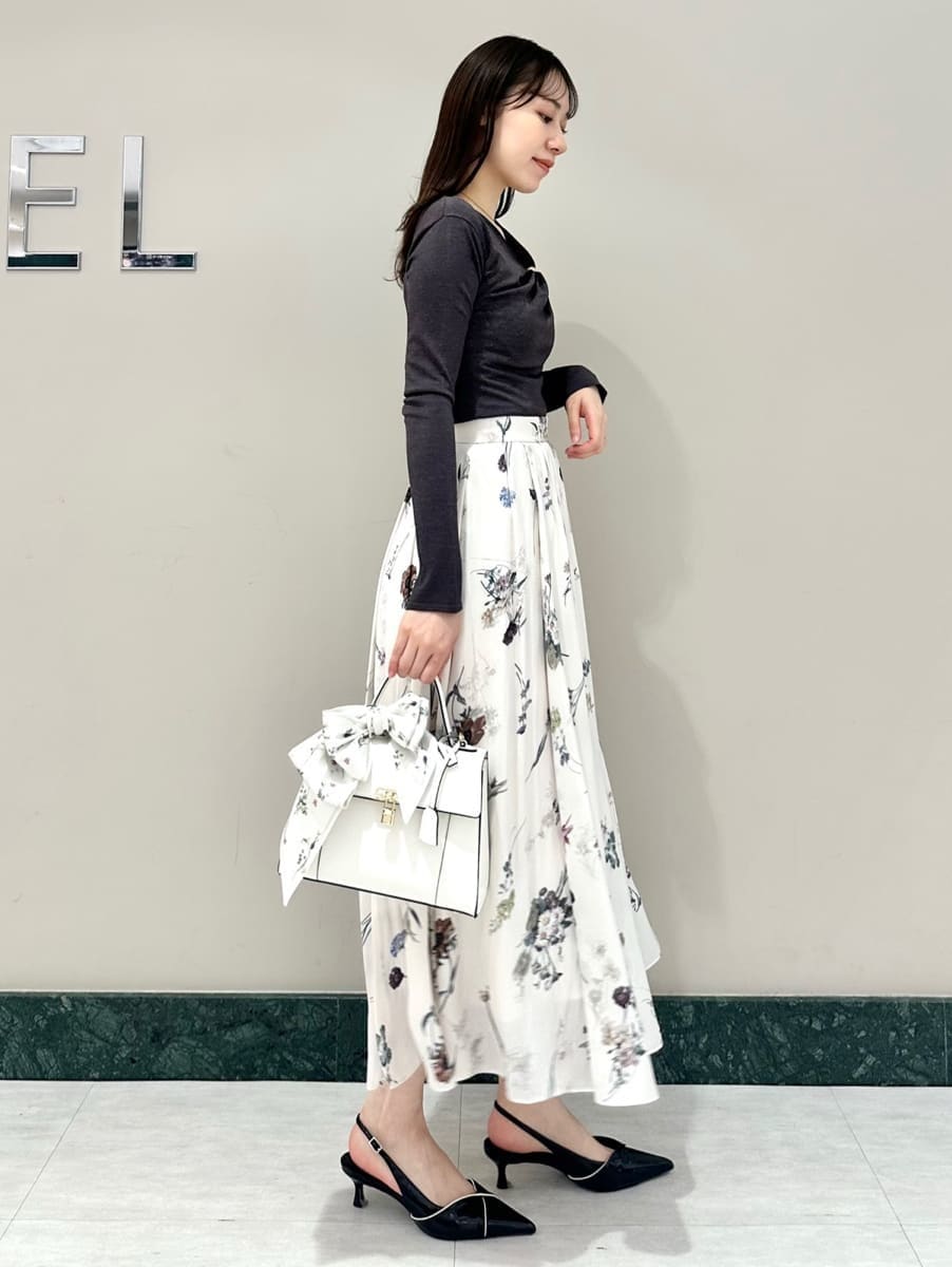 ホワイト系のスカート、グレー系のニット/セーター、ブラック系のパンプスを着用したレディースの冬コーディネートの4枚目の写真