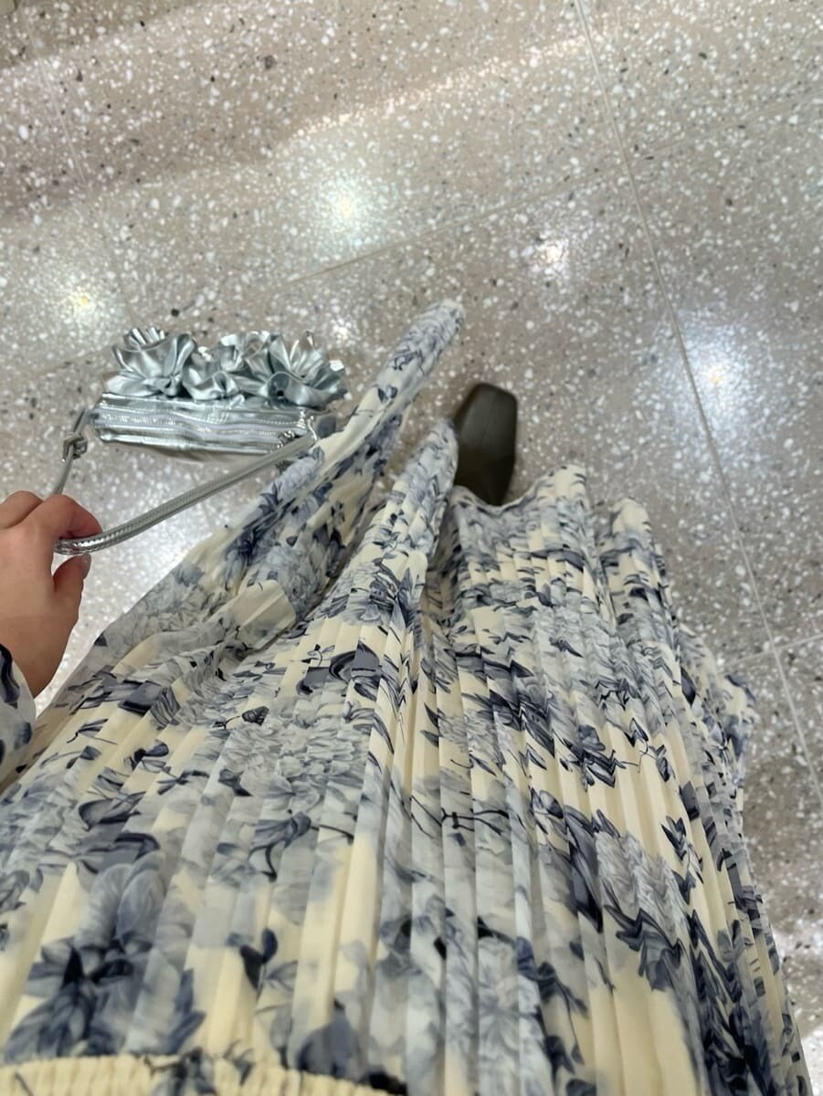 イエロー系のワンピース、シルバー系のハンドバッグを着用したレディースの冬コーディネートの5枚目の写真