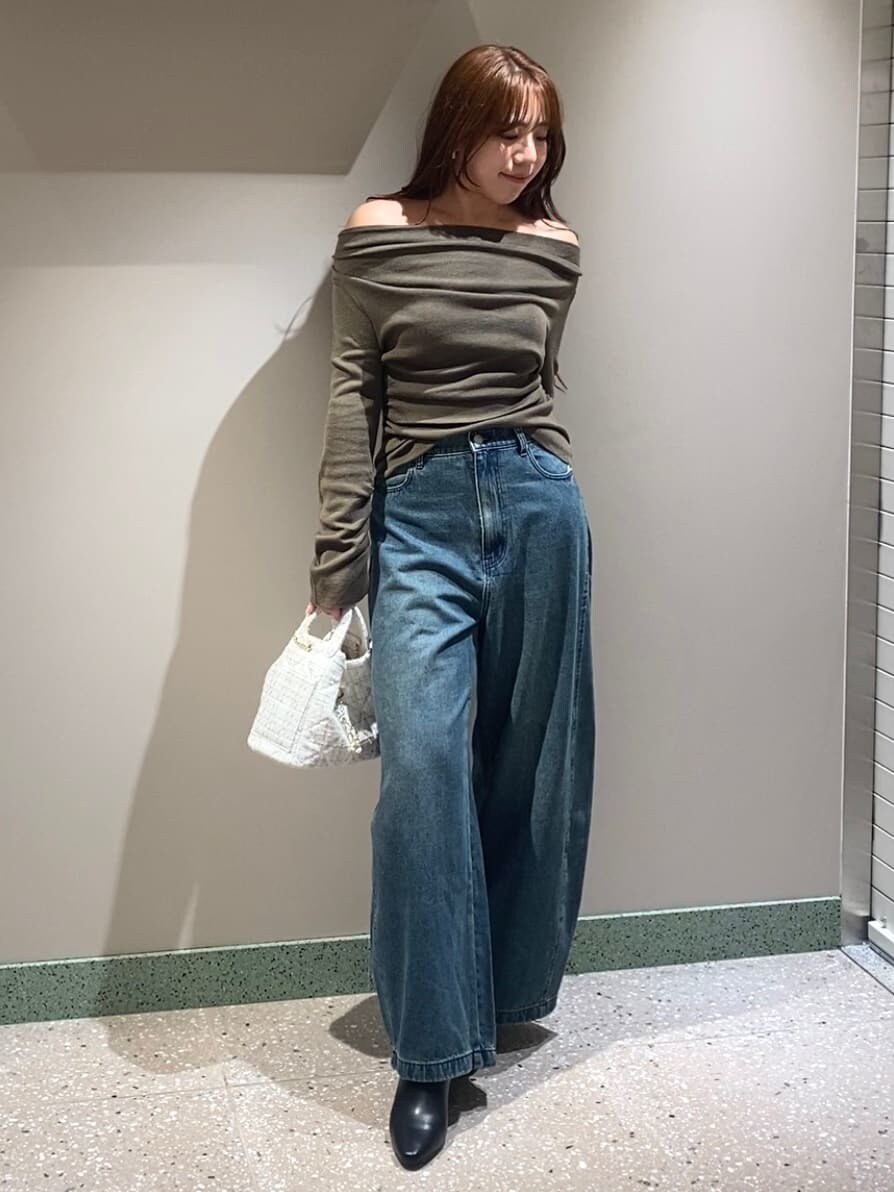 ブルー系のデニムパンツ、ブラウン系のニット/セーター、ブラック系のブーツを着用したレディースの秋コーディネートの3枚目の写真