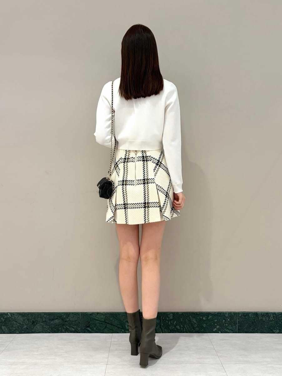 ホワイト系のスカート、ブラック系のショルダーバッグ、ホワイト系のカーディガン/ボレロを着用したレディースの冬コーディネートの3枚目の写真