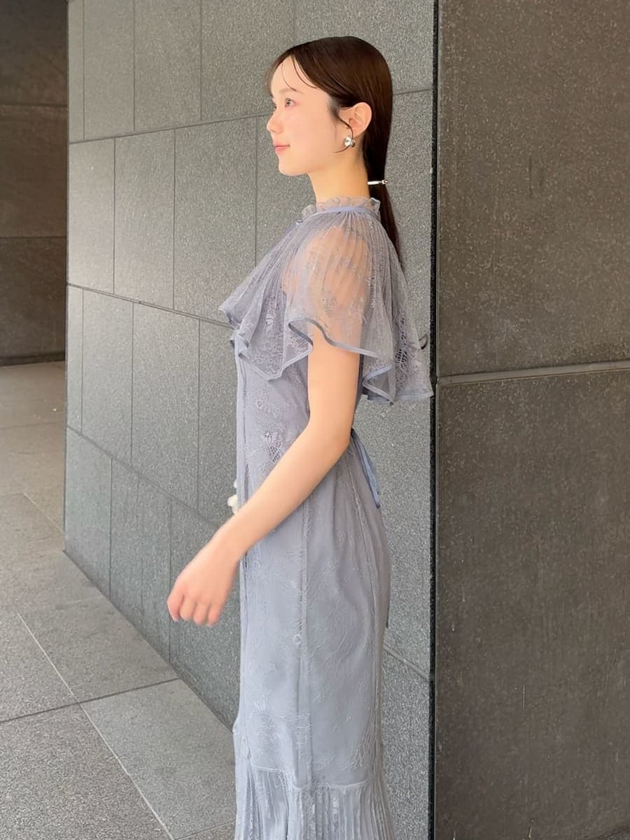 グレー系のドレス、ブラック系のパンプス、ホワイト系のハンドバッグを着用したレディースの春コーディネートの7枚目の写真