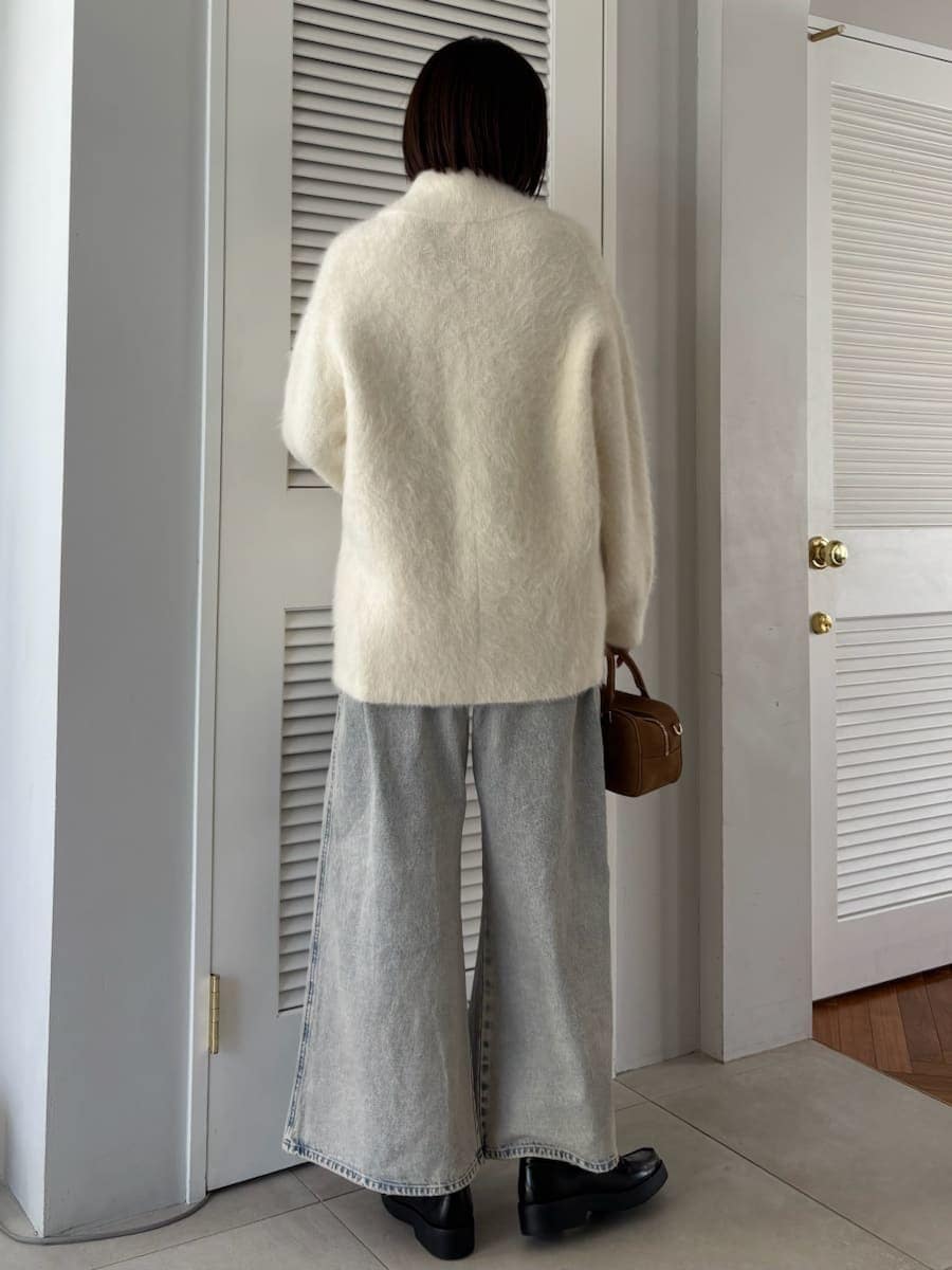 ブラック系のローファー、ホワイト系のブルゾン、イエロー系のボストンバッグを着用したレディースの冬コーディネートの4枚目の写真