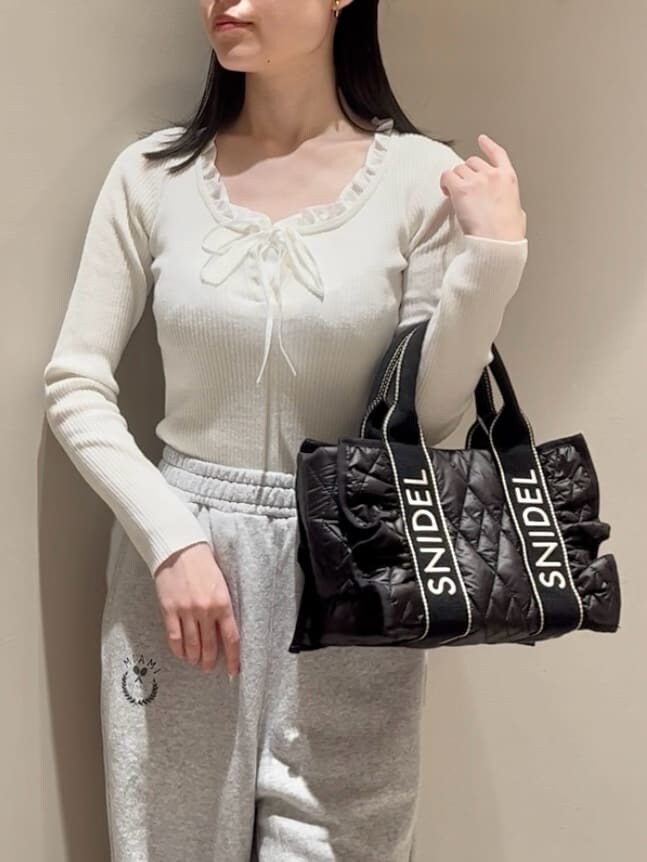 ホワイト系のニット/セーター、グレー系のその他パンツ、ブラック系のブーツを着用したレディースの秋コーディネートの6枚目の写真