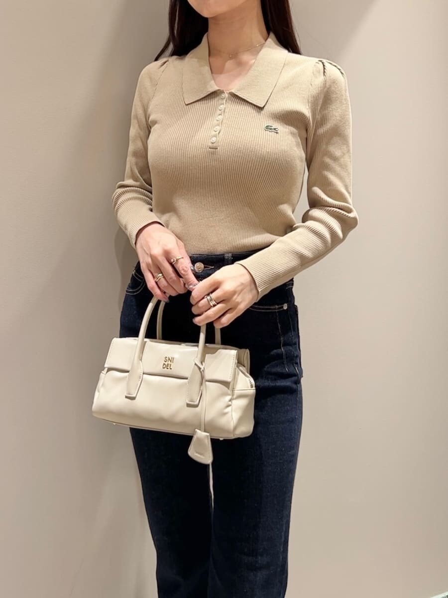 ホワイト系のダウンジャケット/コート、イエロー系のニット/セーター、ブルー系のその他パンツを着用したレディースの秋コーディネートの5枚目の写真