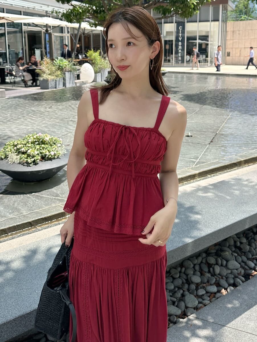 レッド系のスカート、レッド系のシャツ/ブラウス、ゴールド系のピアス（両耳用）を着用したレディースの夏コーディネートの3枚目の写真