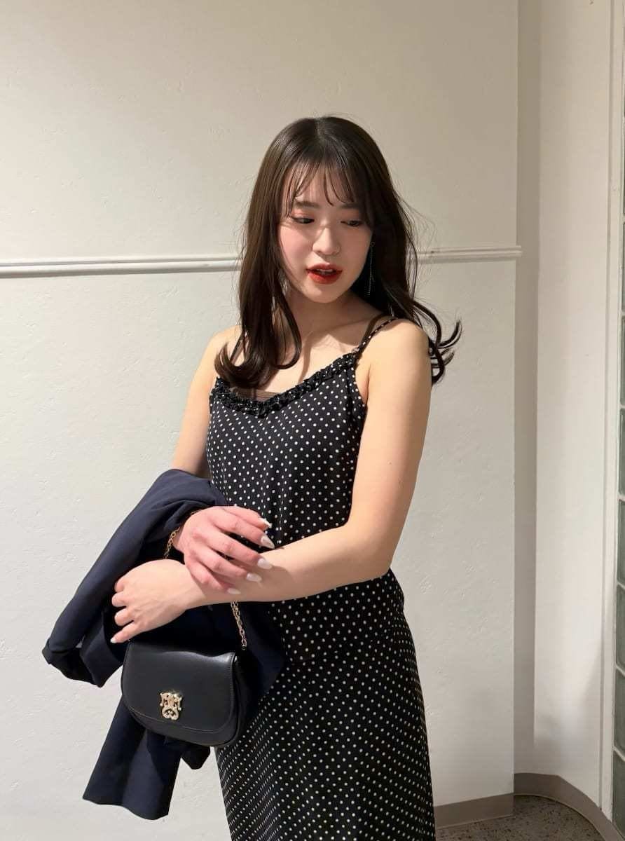 ブルー系のテーラードジャケット、ブラック系のスカート、ブラック系のキャミソールを着用したレディースの冬コーディネートの2枚目の写真