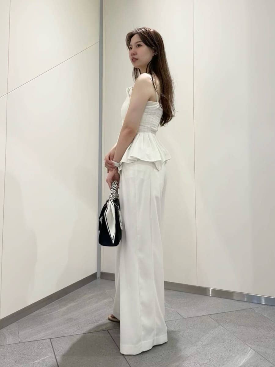 ブラック系のハンドバッグ、ホワイト系のその他パンツ、ホワイト系のその他トップスを着用したレディースの夏コーディネートの4枚目の写真