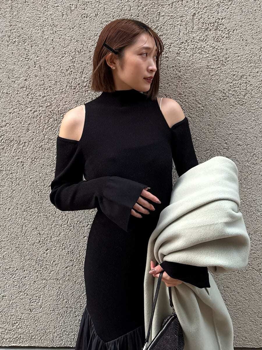 グレー系のブーツ、グリーン系のチェスターコート、ブラック系のワンピースを着用したレディースの秋コーディネートの10枚目の写真