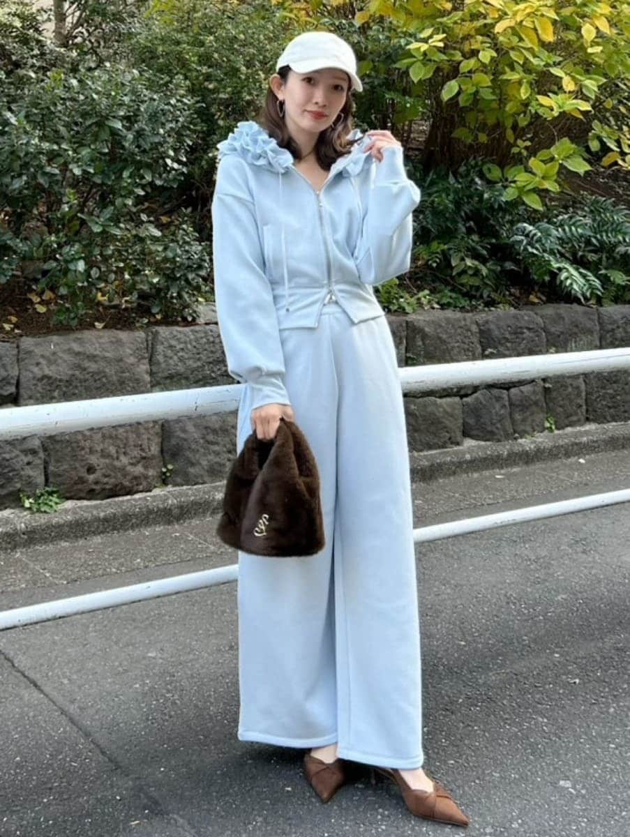 ブラウン系のハンドバッグ、ブルー系のパーカー、ブルー系のスウェットパンツを着用したレディースの冬コーディネートの4枚目の写真