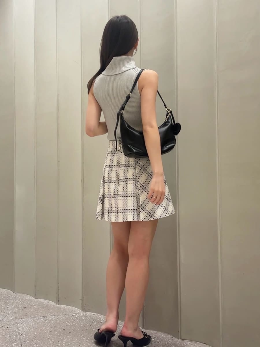ホワイト系のスカート、グレー系のニット/セーター、ブラック系のサンダルを着用したレディースの夏コーディネートの3枚目の写真