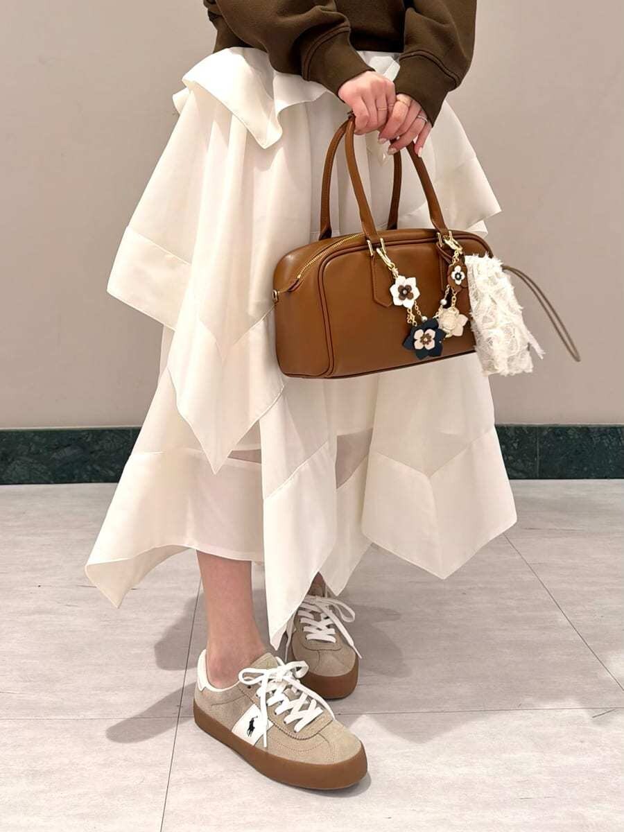 ホワイト系のスカート、ブラウン系のスウェット、イエロー系のボストンバッグを着用したレディースの春コーディネートの7枚目の写真