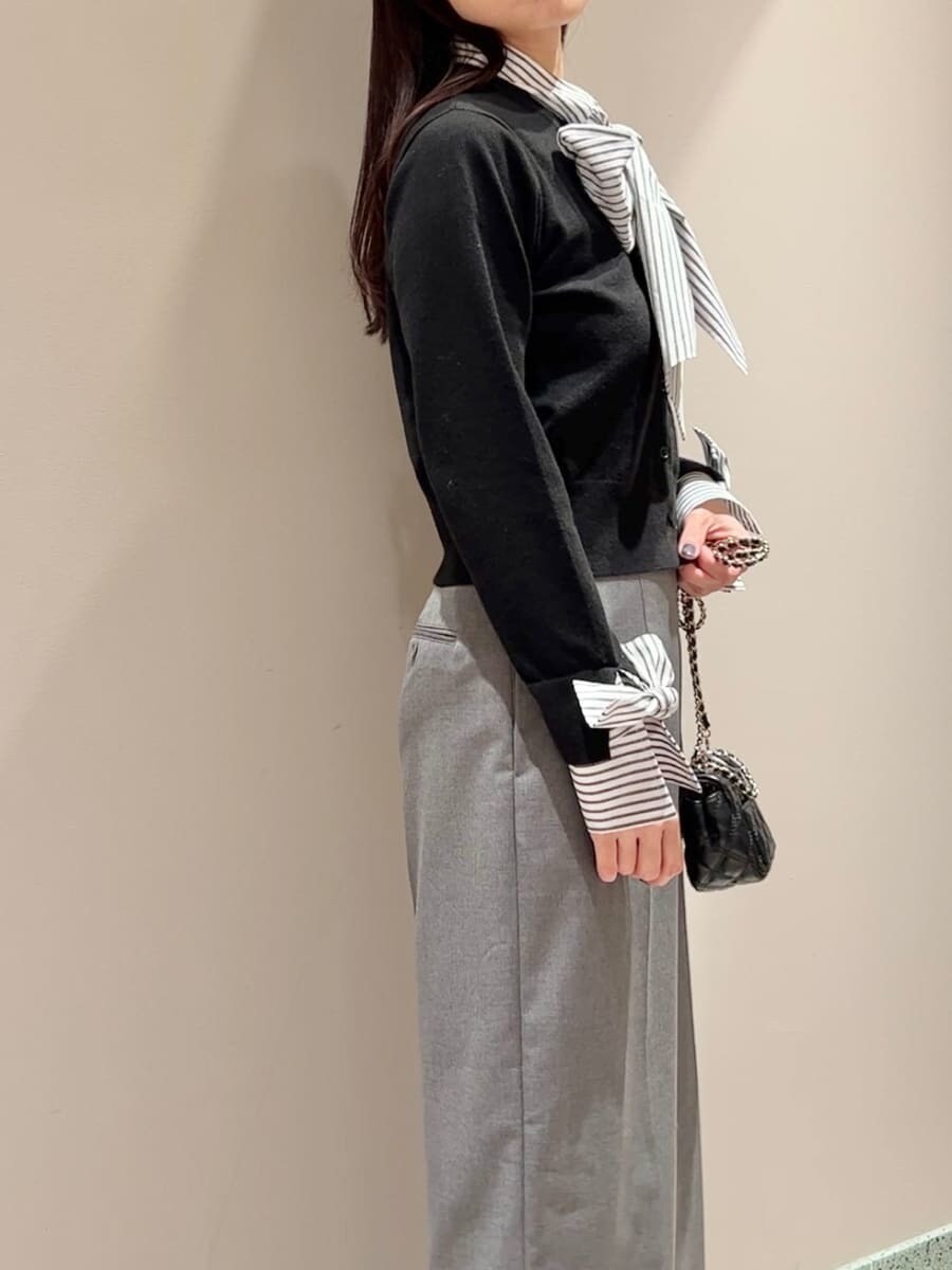ブラック系のニット/セーター、グレー系のスラックス、ブラック系のショルダーバッグを着用したレディースの秋コーディネートの5枚目の写真