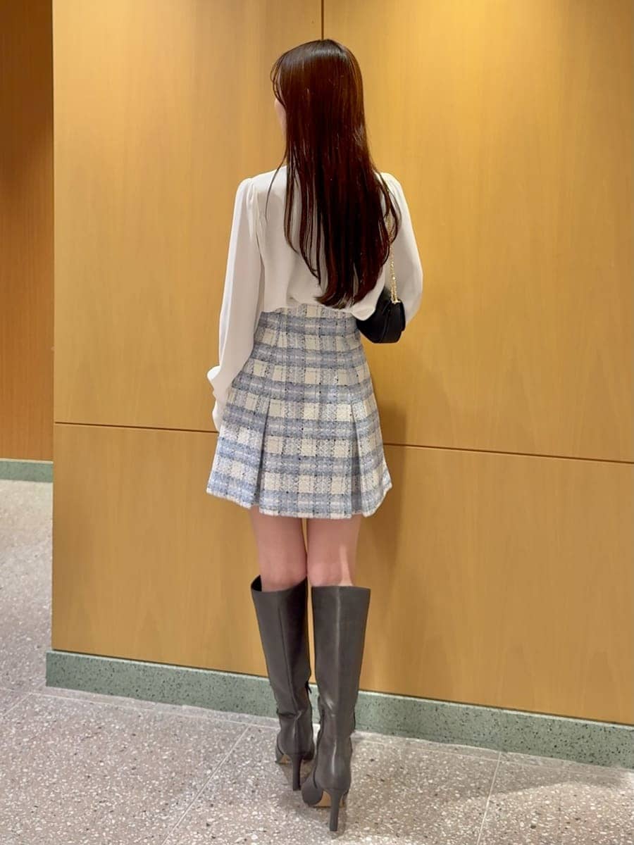 グレー系のブーツ、ブルー系のテーラードジャケット、ブルー系のスカートを着用したレディースの春コーディネートの6枚目の写真