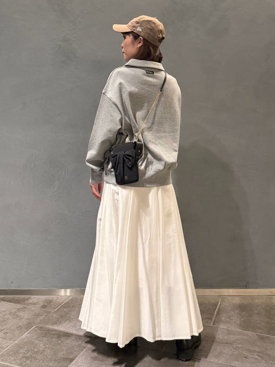グレー系のスウェット、ブラック系のショルダーバッグ、ホワイト系のスカートを着用したレディースの春コーディネートの4枚目の写真