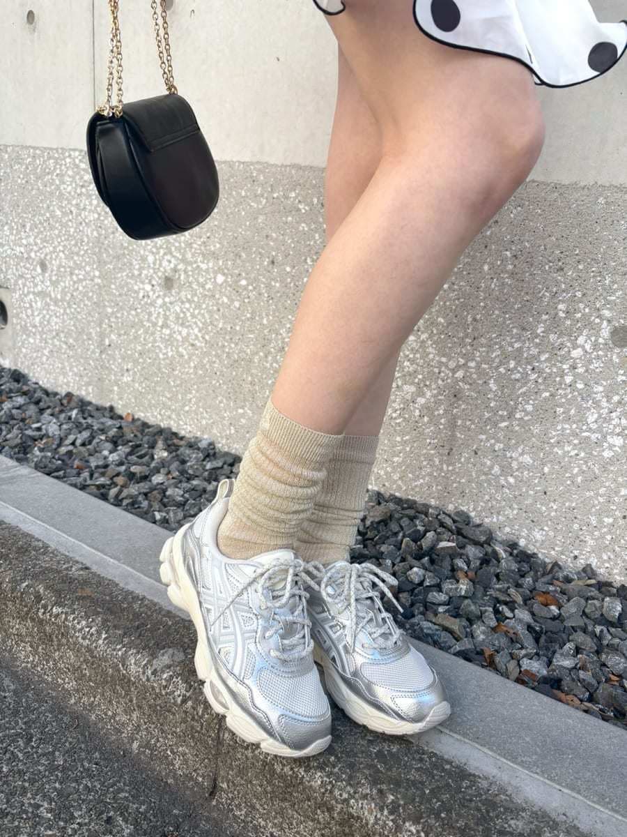 ホワイト系のワンピース、ブラック系のショルダーバッグ、シルバー系のスニーカーを着用したレディースの冬コーディネートの8枚目の写真