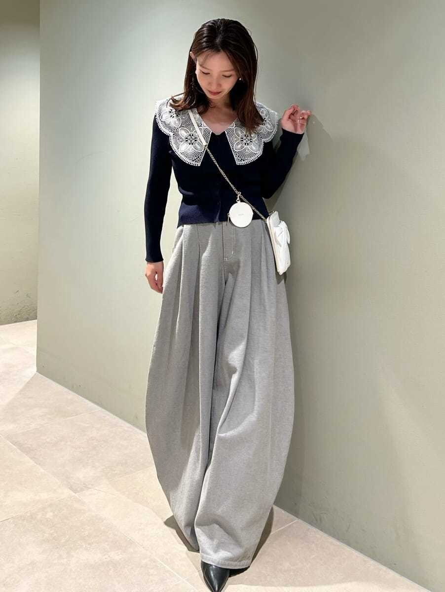 ブルー系のニット/セーター、グレー系のデニムパンツ、ホワイト系のショルダーバッグを着用したレディースの冬コーディネートの5枚目の写真