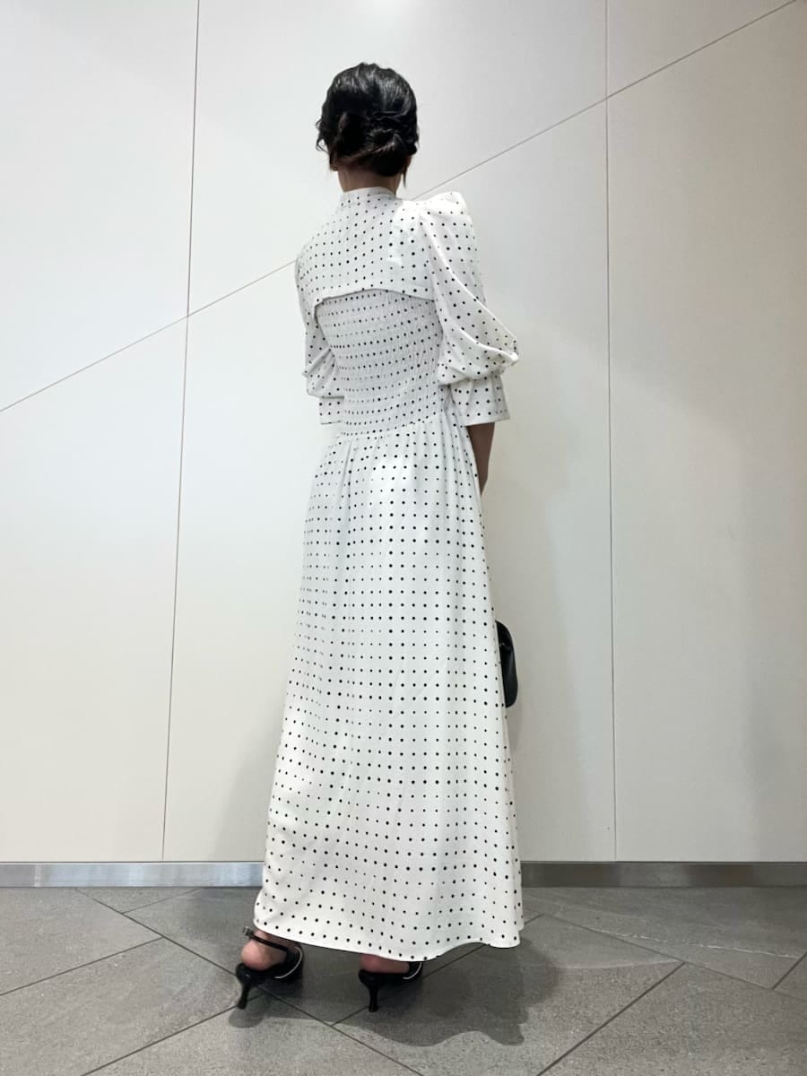 ブラック系のパンプス、ブラック系のボストンバッグ、ホワイト系のワンピースを着用したレディースの春コーディネートの3枚目の写真