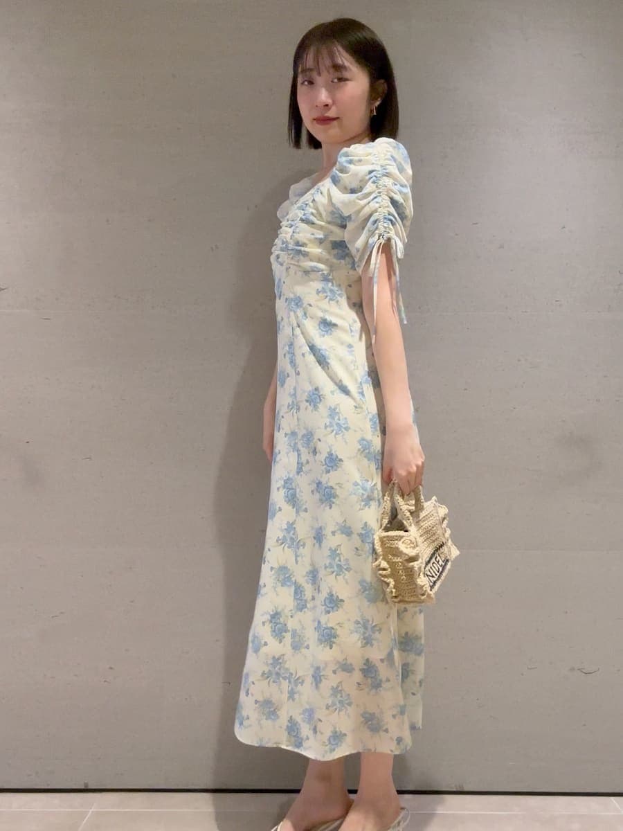 ベージュ系のショルダーバッグ、イエロー系のワンピースを着用したレディースの春コーディネートの3枚目の写真