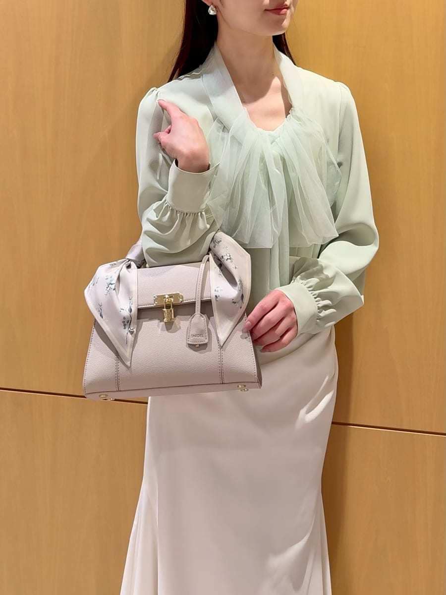 ブラック系のブーツ、ホワイト系のトレンチコート、ホワイト系のスカートを着用したレディースの冬コーディネートの10枚目の写真