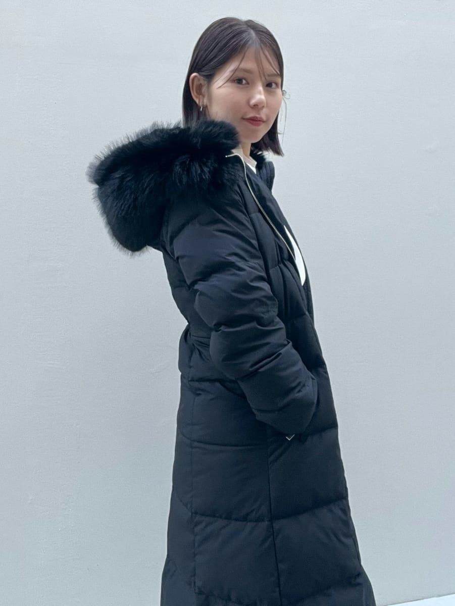 ホワイト系のスカート、ブラック系のブーツ、ブラック系のダウンジャケット/コートを着用したレディースの冬コーディネートの4枚目の写真