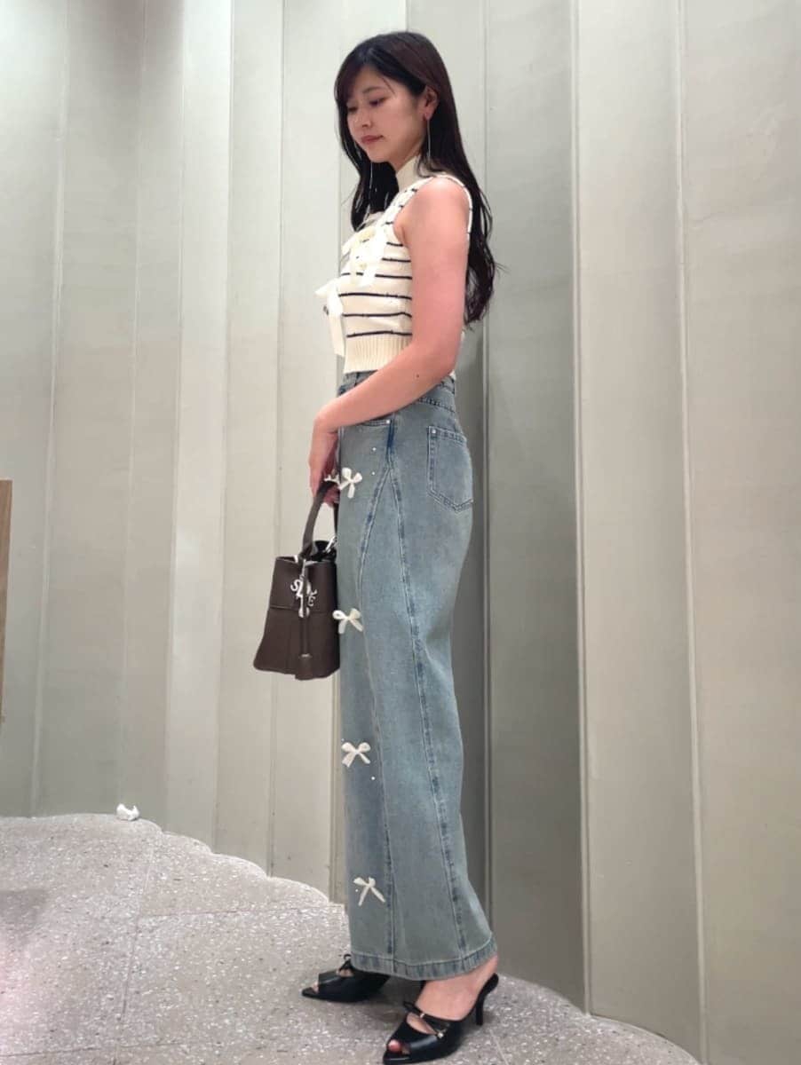 ブラウン系のハンドバッグ、ブルー系のその他パンツ、その他のニット/セーターを着用したレディースの夏コーディネートの4枚目の写真