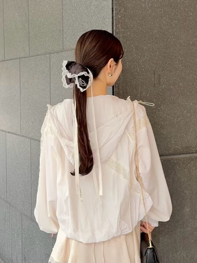 ホワイト系のキャミソール、ホワイト系のブルゾン、ブラック系のショルダーバッグを着用したレディースの春コーディネートの7枚目の写真