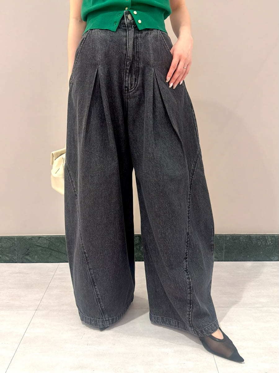 ブラック系のデニムパンツ、グリーン系のニット/セーター、ホワイト系のボストンバッグを着用したレディースの夏コーディネートの5枚目の写真