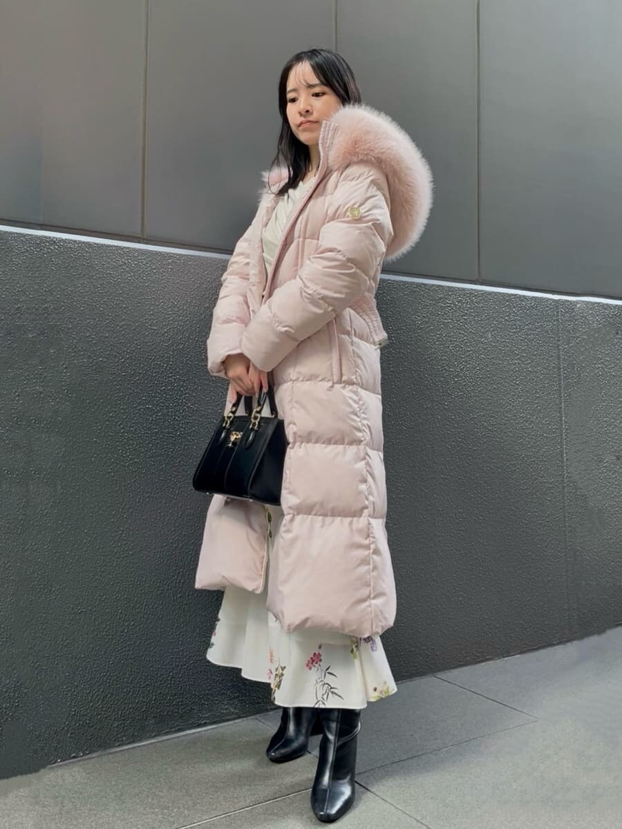 ブラック系のブーツ、ピンク系のダウンジャケット/コート、ブラック系のハンドバッグを着用したレディースの冬コーディネートの2枚目の写真