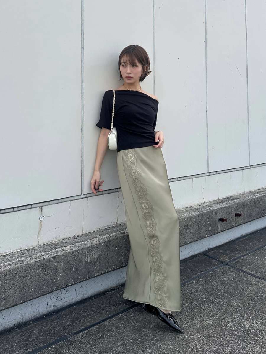 ホワイト系のショルダーバッグ、グリーン系のスカート、ブラック系のTシャツ/カットソーを着用したレディースの夏コーディネートの2枚目の写真