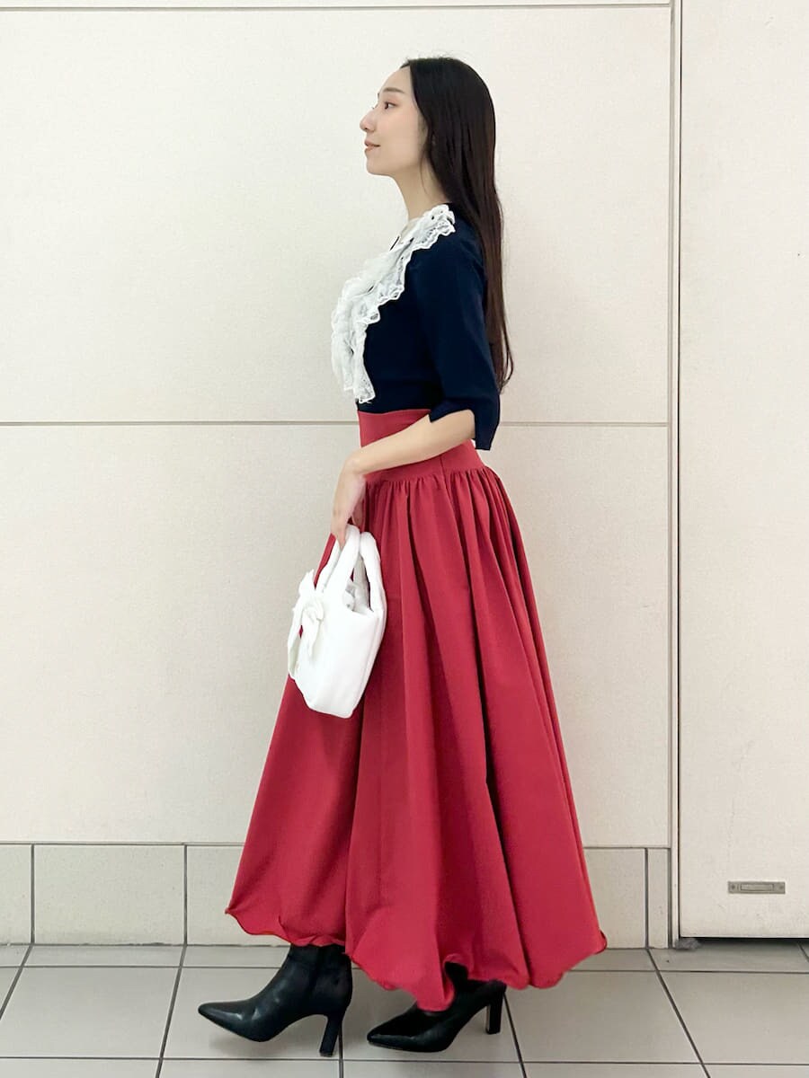 ブラック系のブーツ、ブルー系のニット/セーター、レッド系のスカートを着用したレディースの冬コーディネートの3枚目の写真