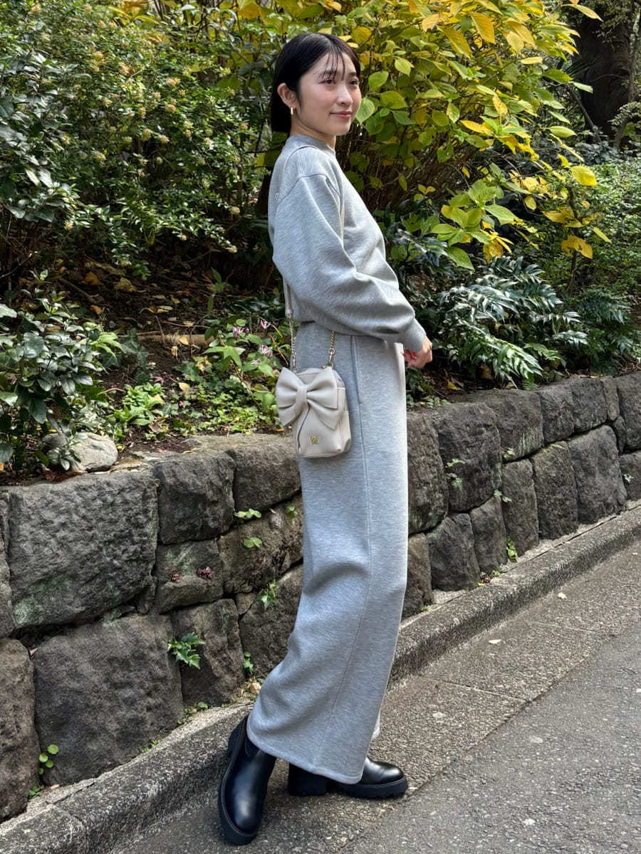 ホワイト系のショルダーバッグ、グレー系のスウェット、グレー系のスウェットパンツを着用したレディースの冬コーディネートの2枚目の写真