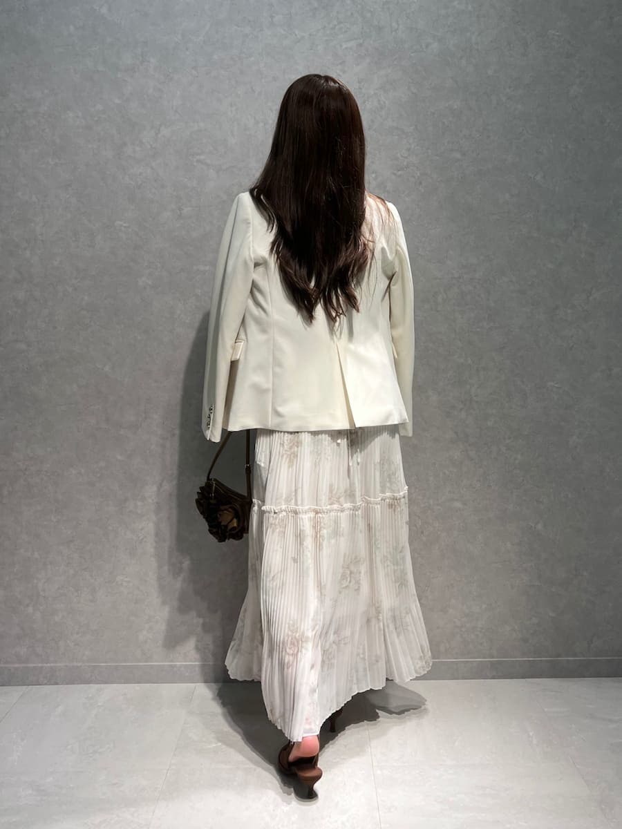 ホワイト系のテーラードジャケット、ピンク系のワンピース、ブラウン系のパンプスを着用したレディースの春コーディネートの3枚目の写真