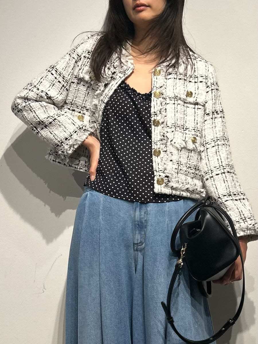 ホワイト系のノーカラージャケット、ブラック系のキャミソール、ブラック系のパンプスを着用したレディースの春コーディネートの6枚目の写真