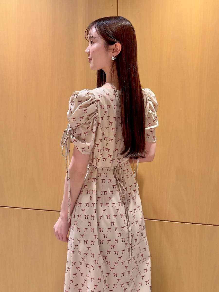 ホワイト系のハンドバッグ、ベージュ系のワンピース、レッド系のカーディガン/ボレロを着用したレディースの冬コーディネートの9枚目の写真