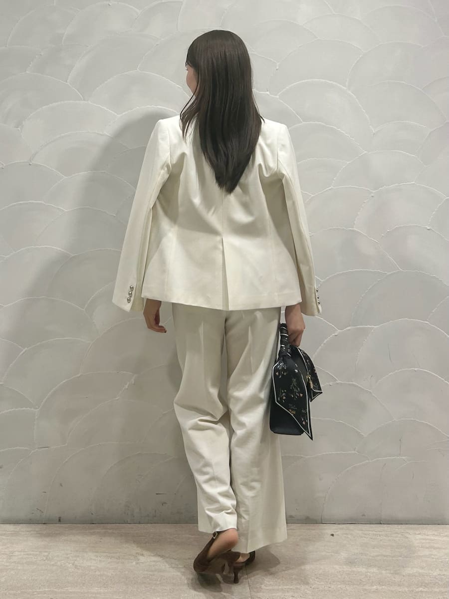 ホワイト系のテーラードジャケット、ホワイト系のスラックス、ブラウン系のパンプスを着用したレディースの冬コーディネートの2枚目の写真