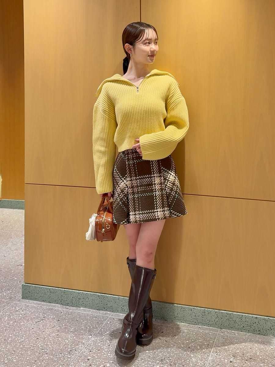 ブラウン系のスカート、イエロー系のニット/セーター、ブラウン系のブーツを着用したレディースの冬コーディネートの3枚目の写真