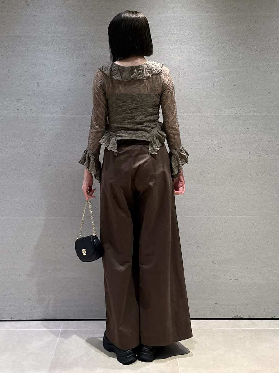 ブラウン系のその他パンツ、グリーン系のTシャツ/カットソー、ブラック系のショルダーバッグを着用したレディースの冬コーディネートの4枚目の写真